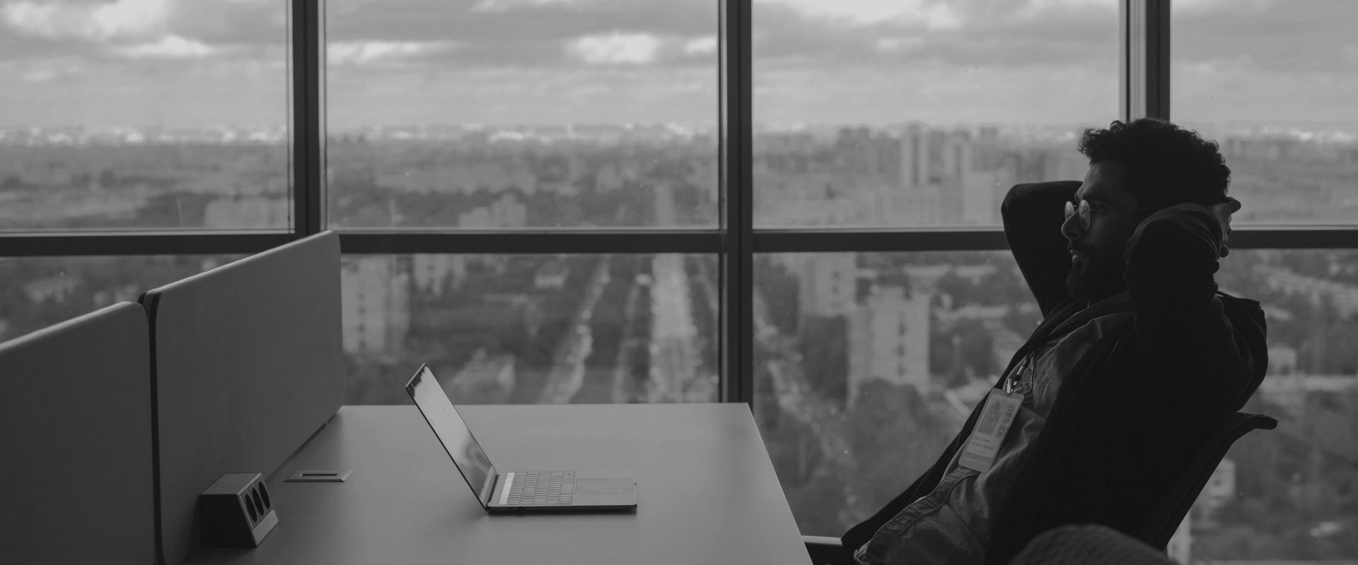 Man sitting in office looking at laptop